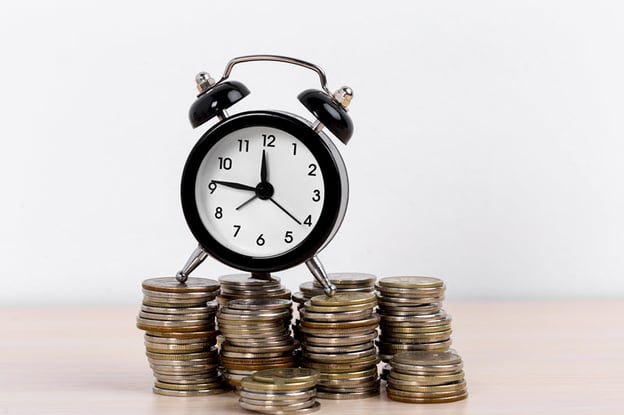 alarm-clock-and-coins-on-white-background